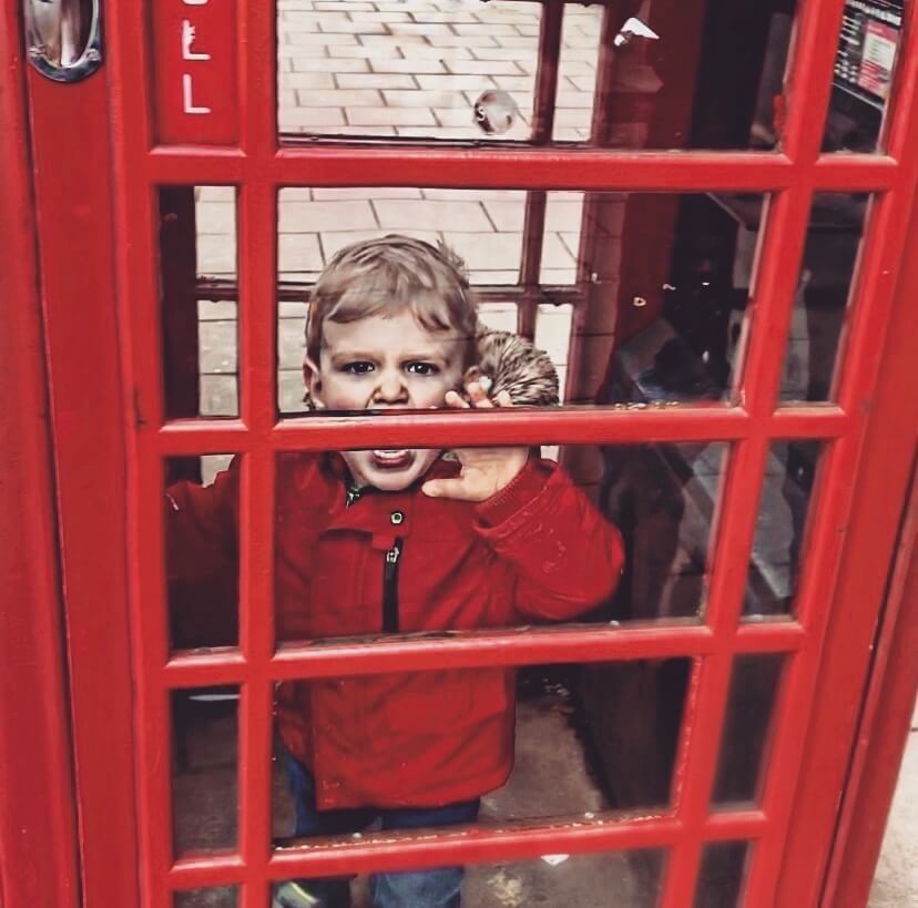 A toddler having a tantrum in a phone box